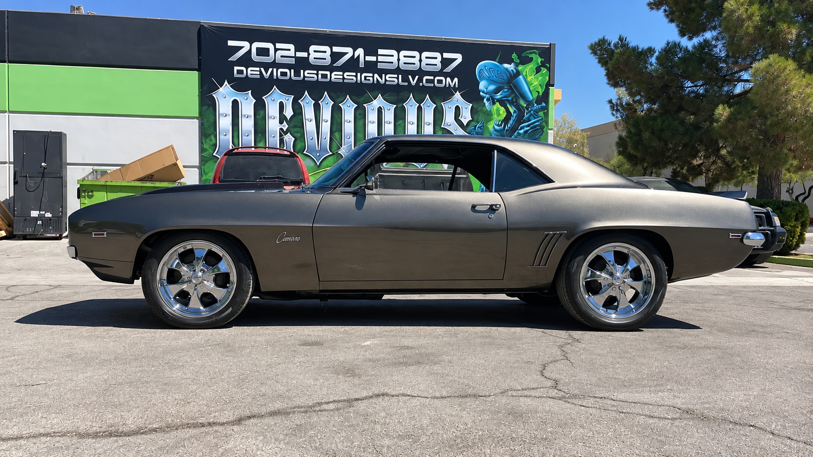 Classic tan coupe parked outdoors in front of a banner at a car show