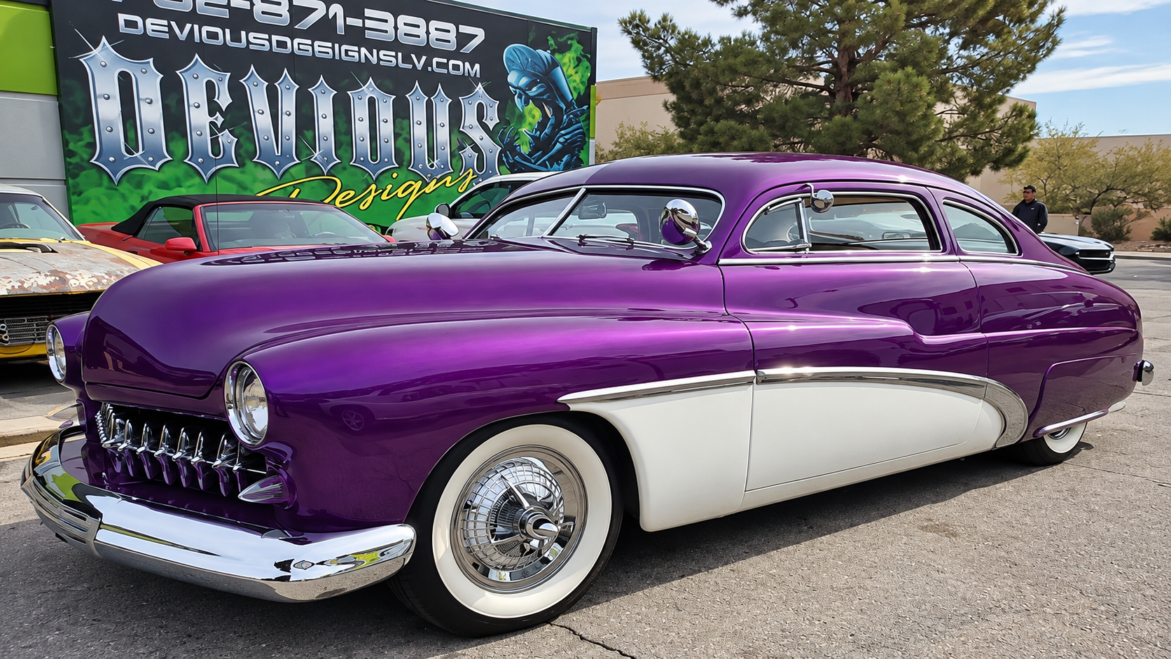 Purple classic car with white lower panels parked outdoors at a car show