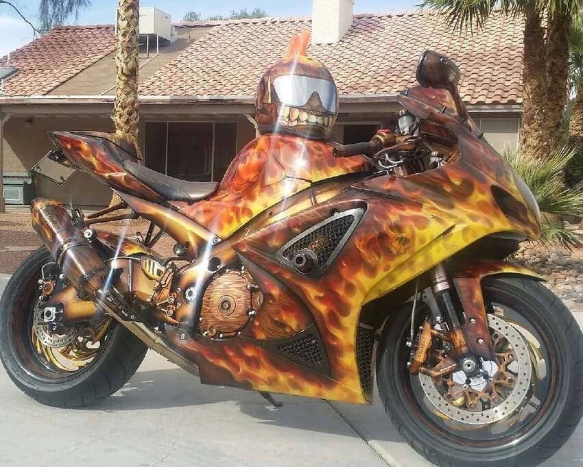 Flame-painted sport motorcycle parked outdoors in front of a house