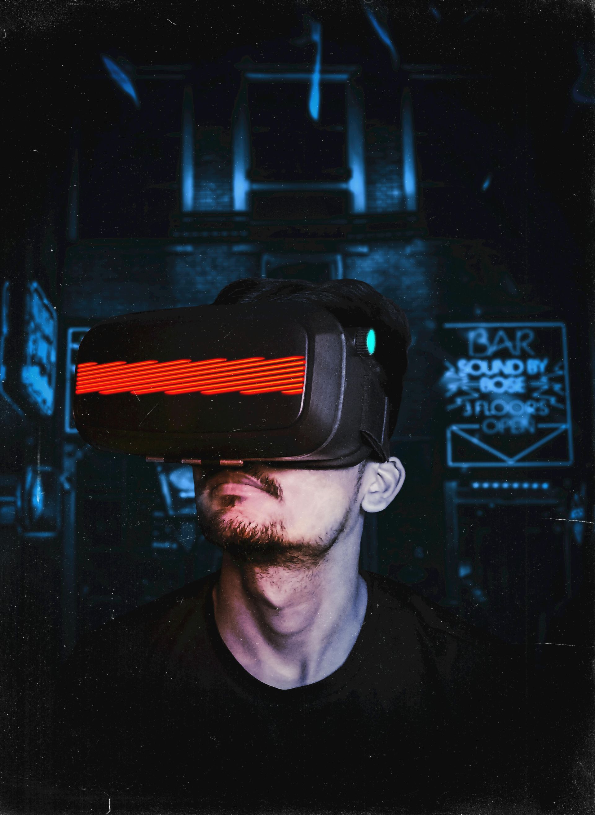 Man wearing VR headset with neon lights behind him.