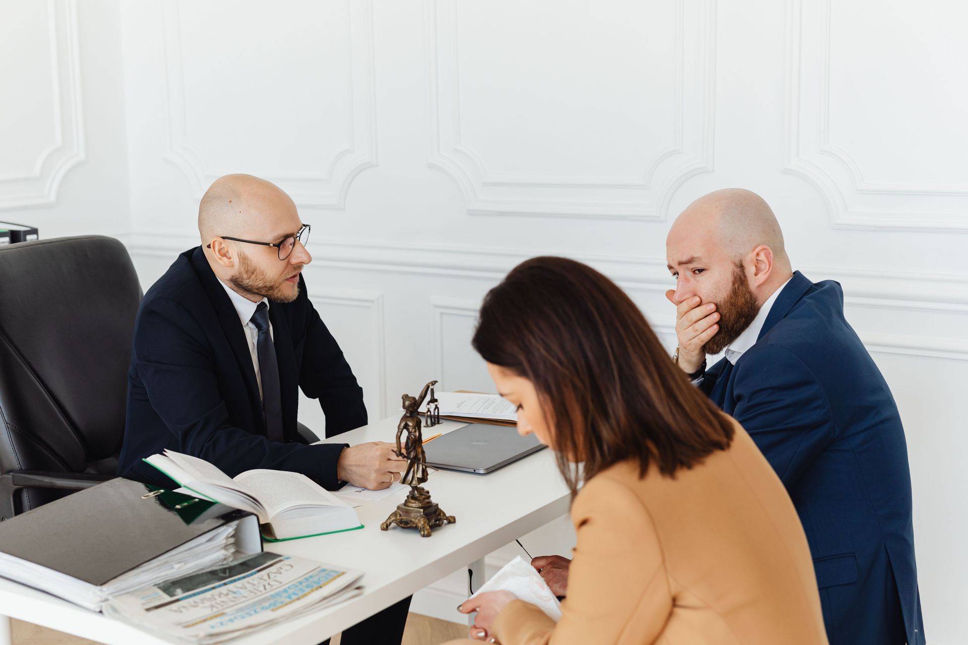 Business owners meeting with a neutral mediator at a conference table to resolve a dispute