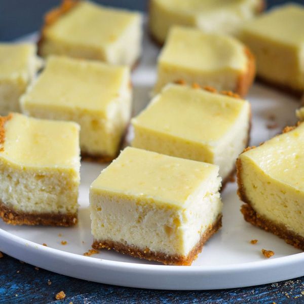 a white plate topped with slices of cheesecake on a table .