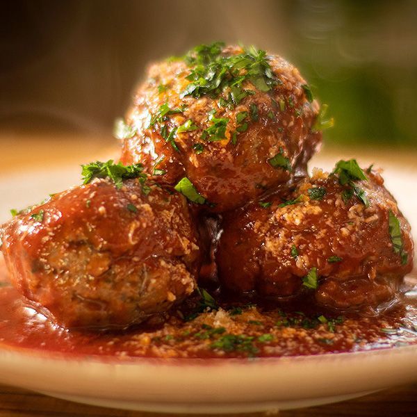 a plate of arancini bites with a bowl of sauce on the side