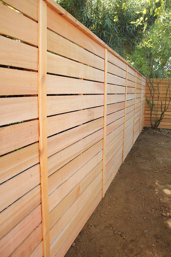 A wooden fence is sitting in the middle of a dirt field.