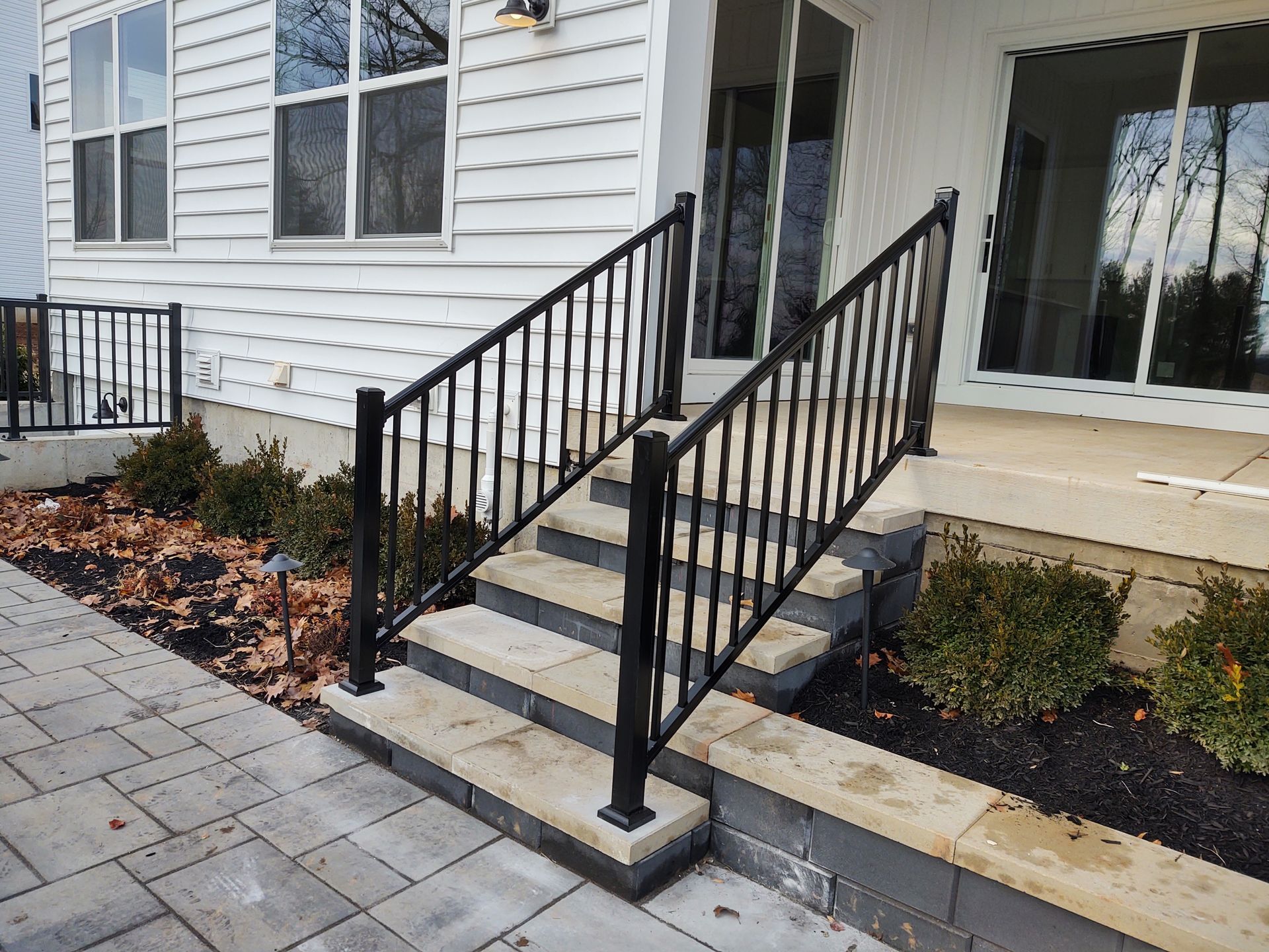 A white house with a black railing and stairs