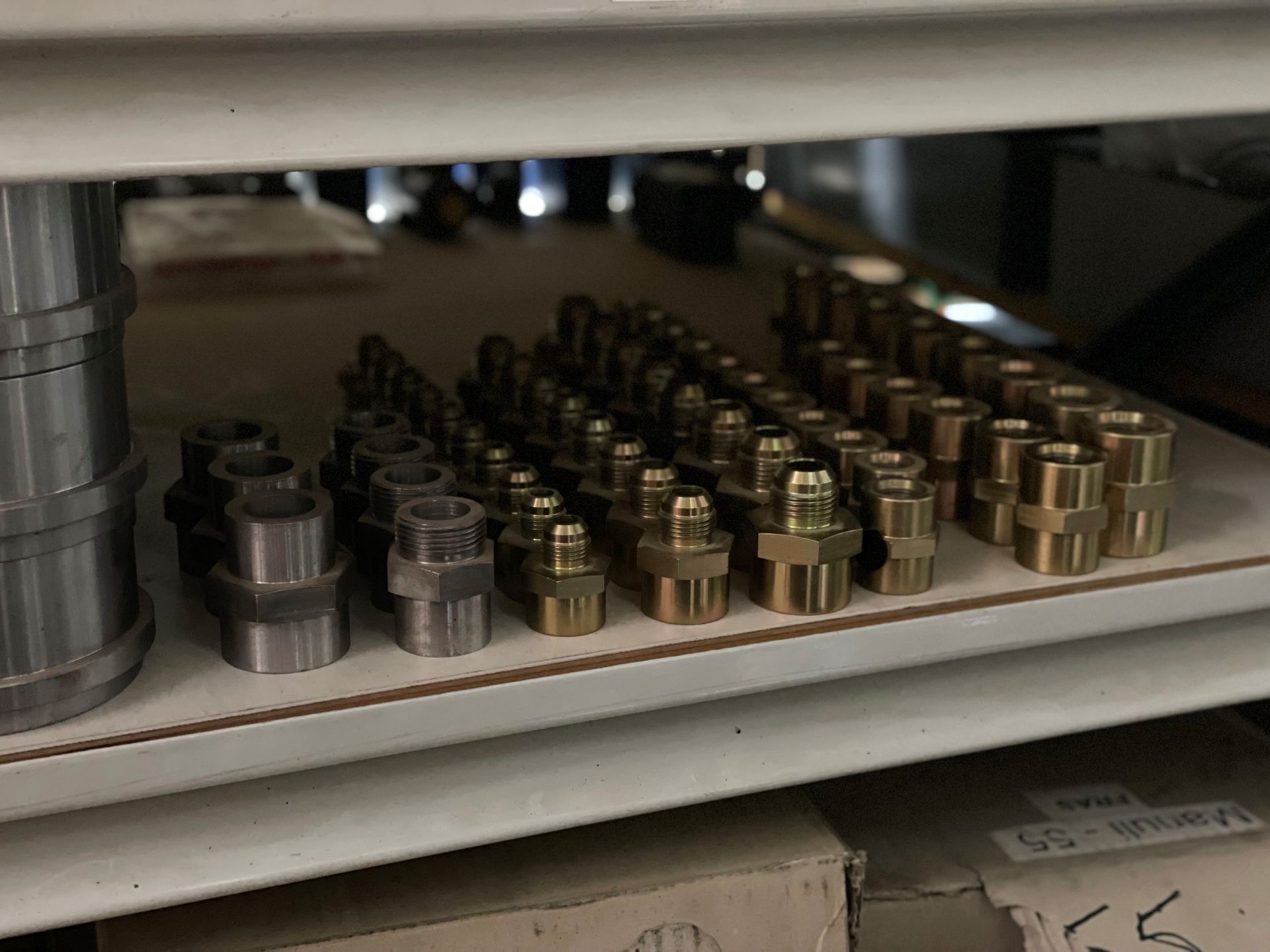 A bunch of brass fittings are lined up on a shelf