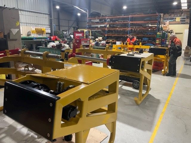 A warehouse filled with lots of machinery and people working on them.