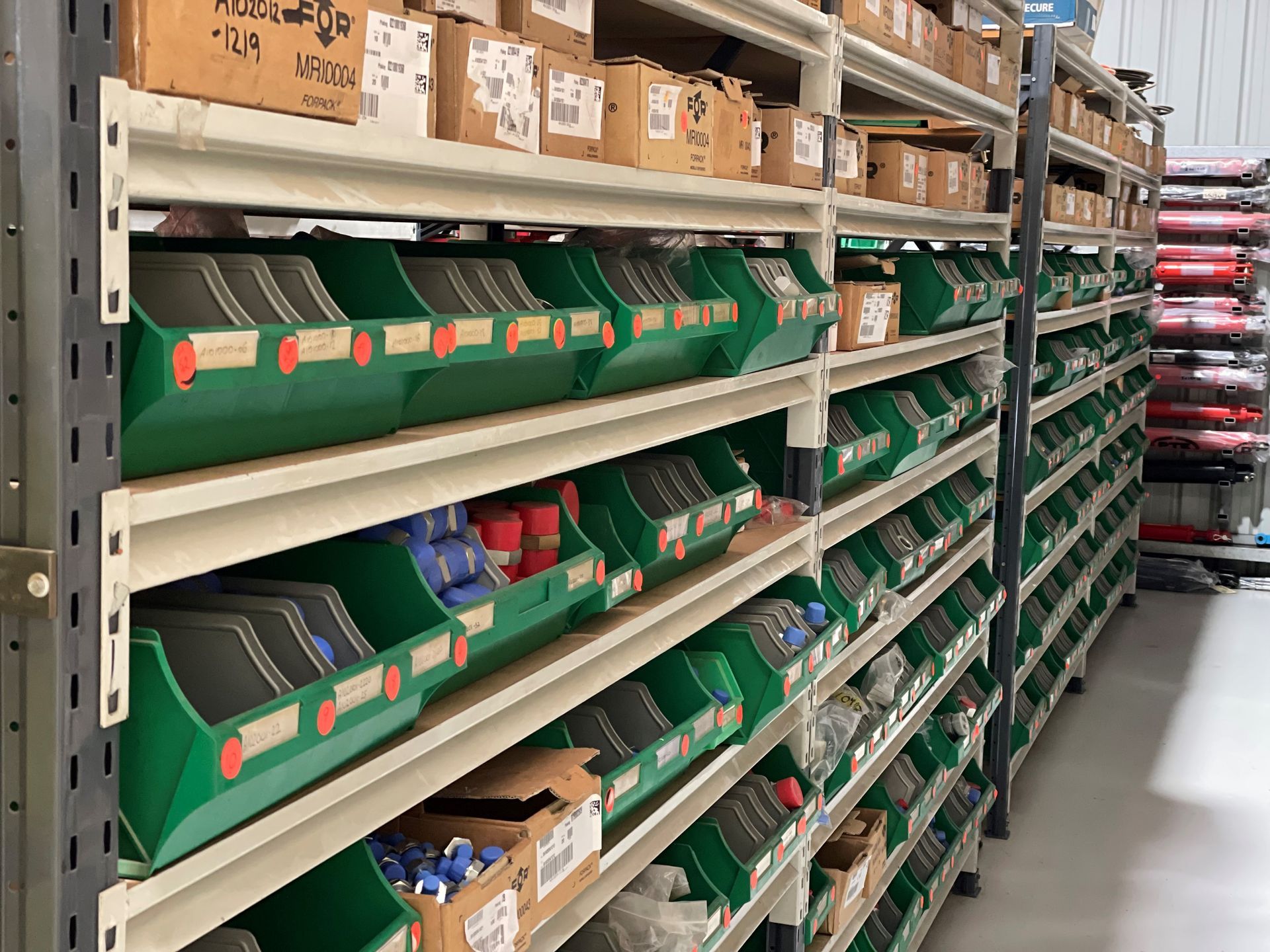 A warehouse filled with lots of green bins and boxes.