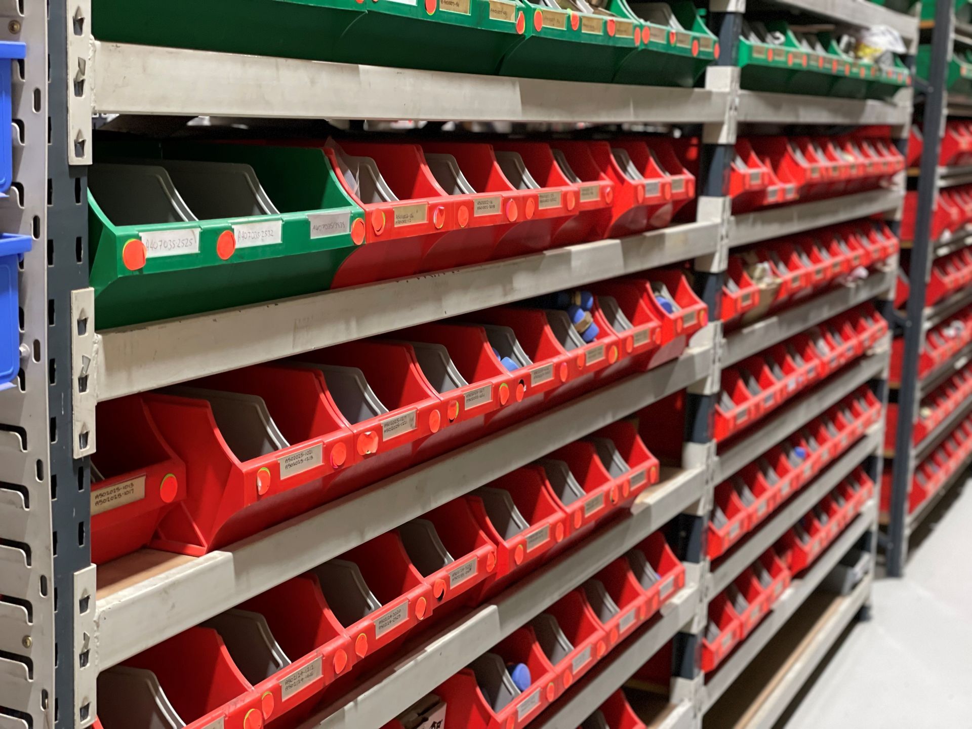 A warehouse filled with lots of red and green bins.
