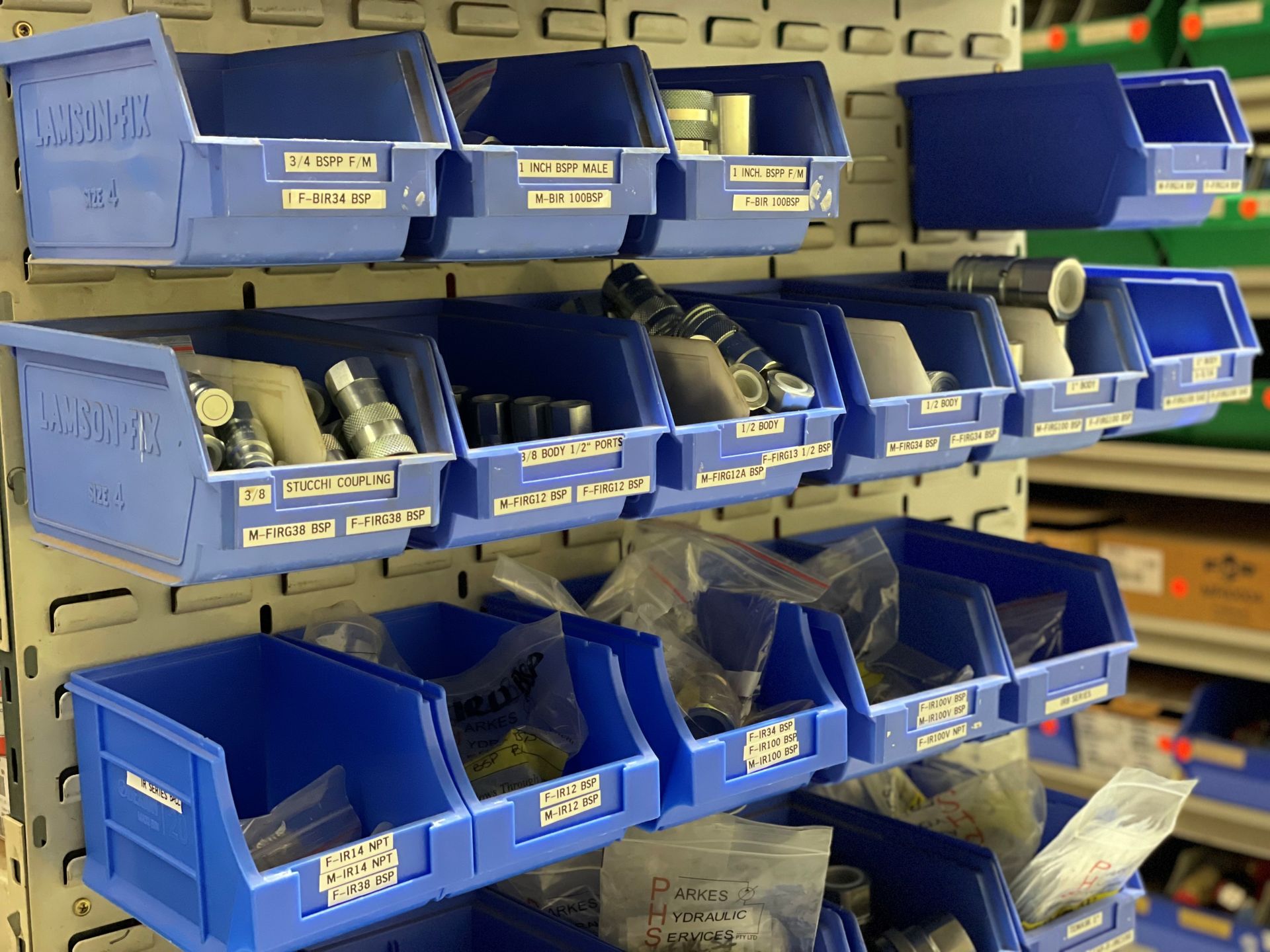 A bunch of blue bins filled with different types of parts