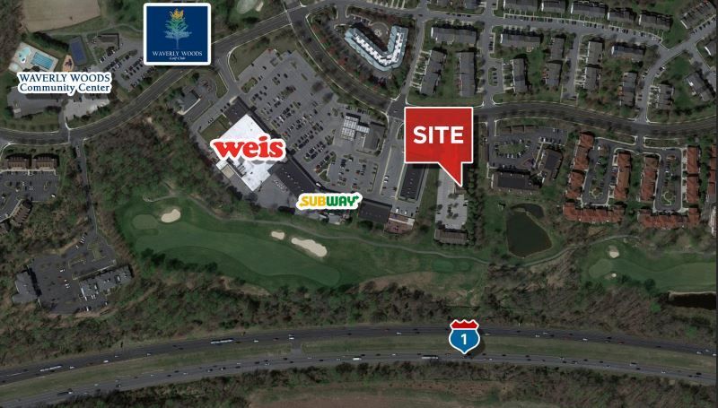 An aerial view of a shopping center with a sign that says site