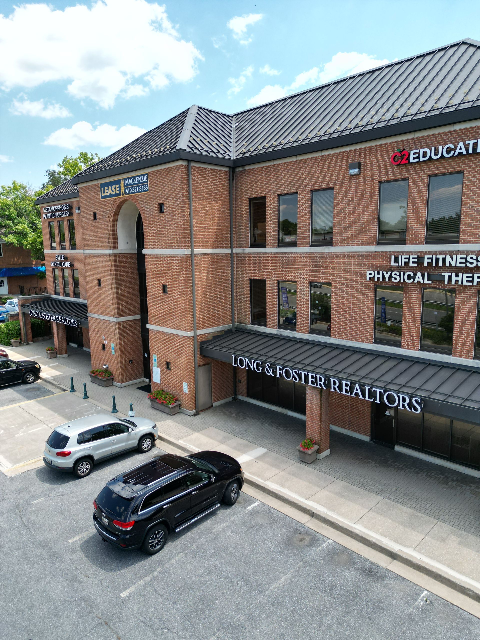 An aerial view of a large brick building with cars parked in front of it