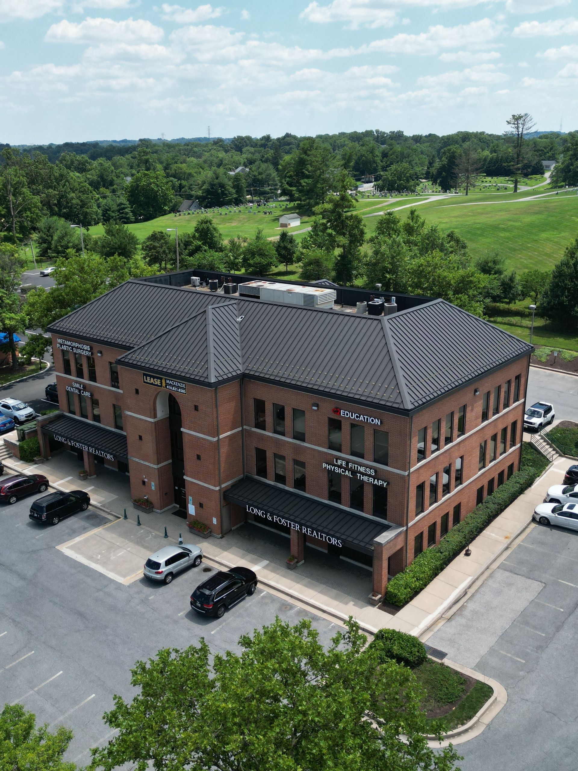 An aerial view of a large brick building with cars parked in front of it