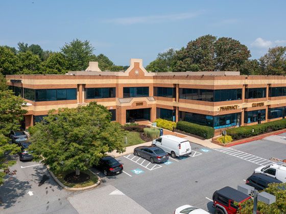 An aerial view of a large office building with cars parked in front of it.