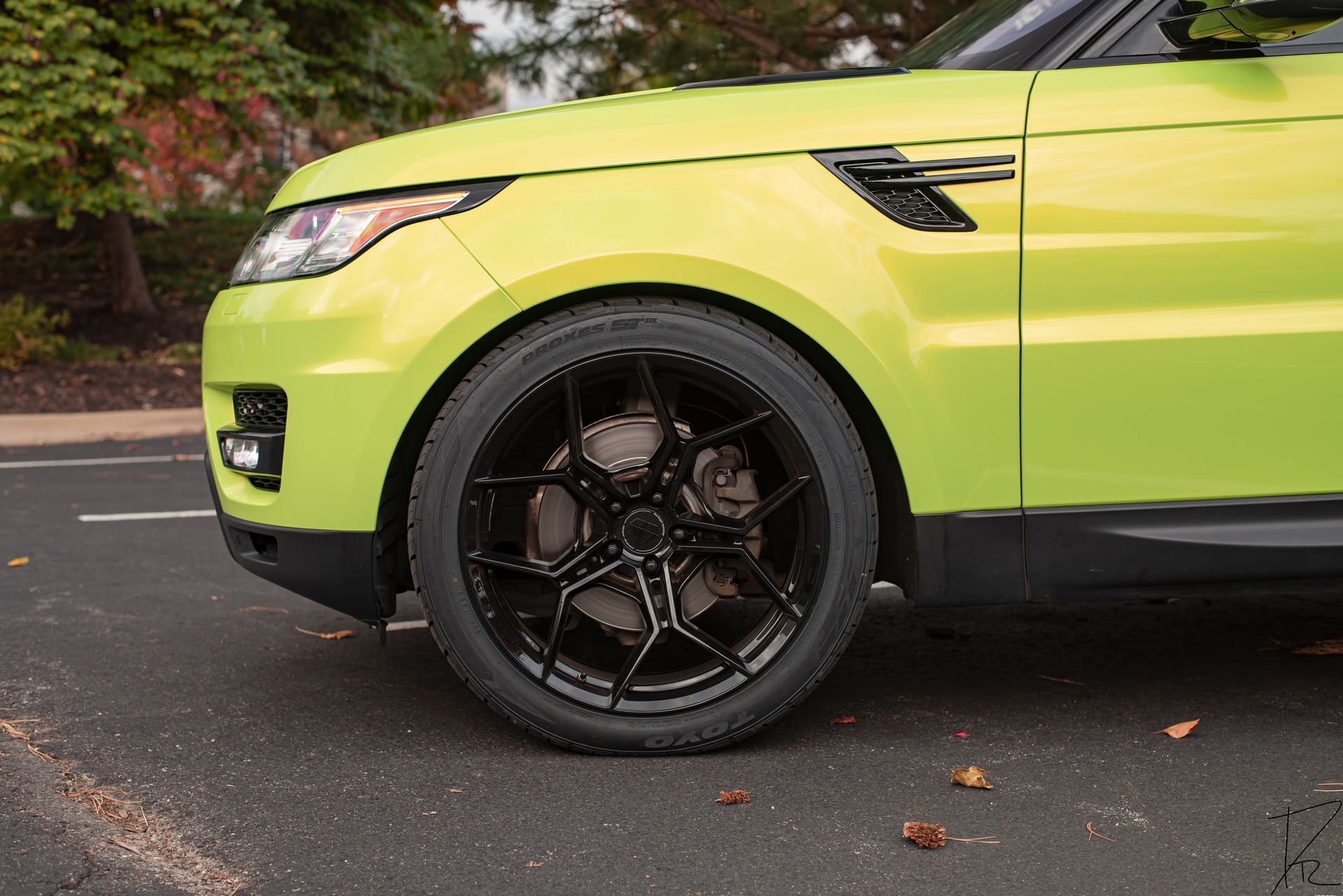 Lime green SUV with black wheels parked on a street