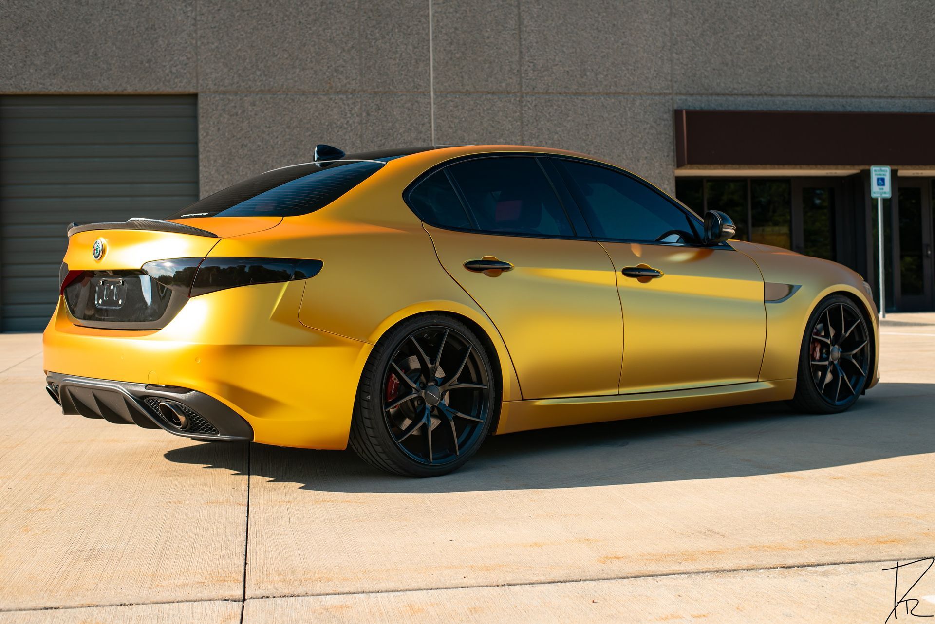 Yellow sports sedan parked outside a building, side view in bright sunlight