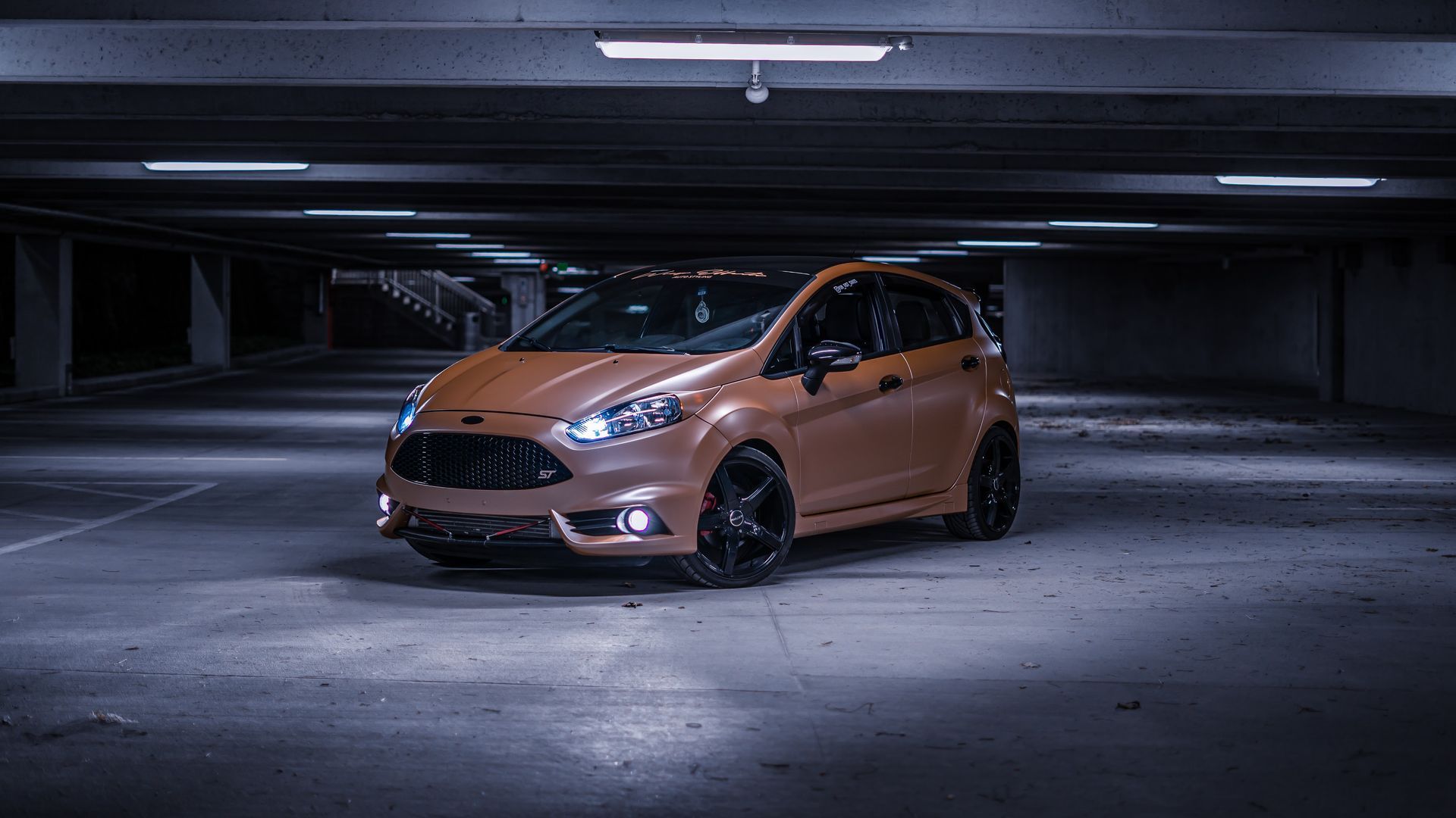 Copper car parked in a dimly lit underground garage