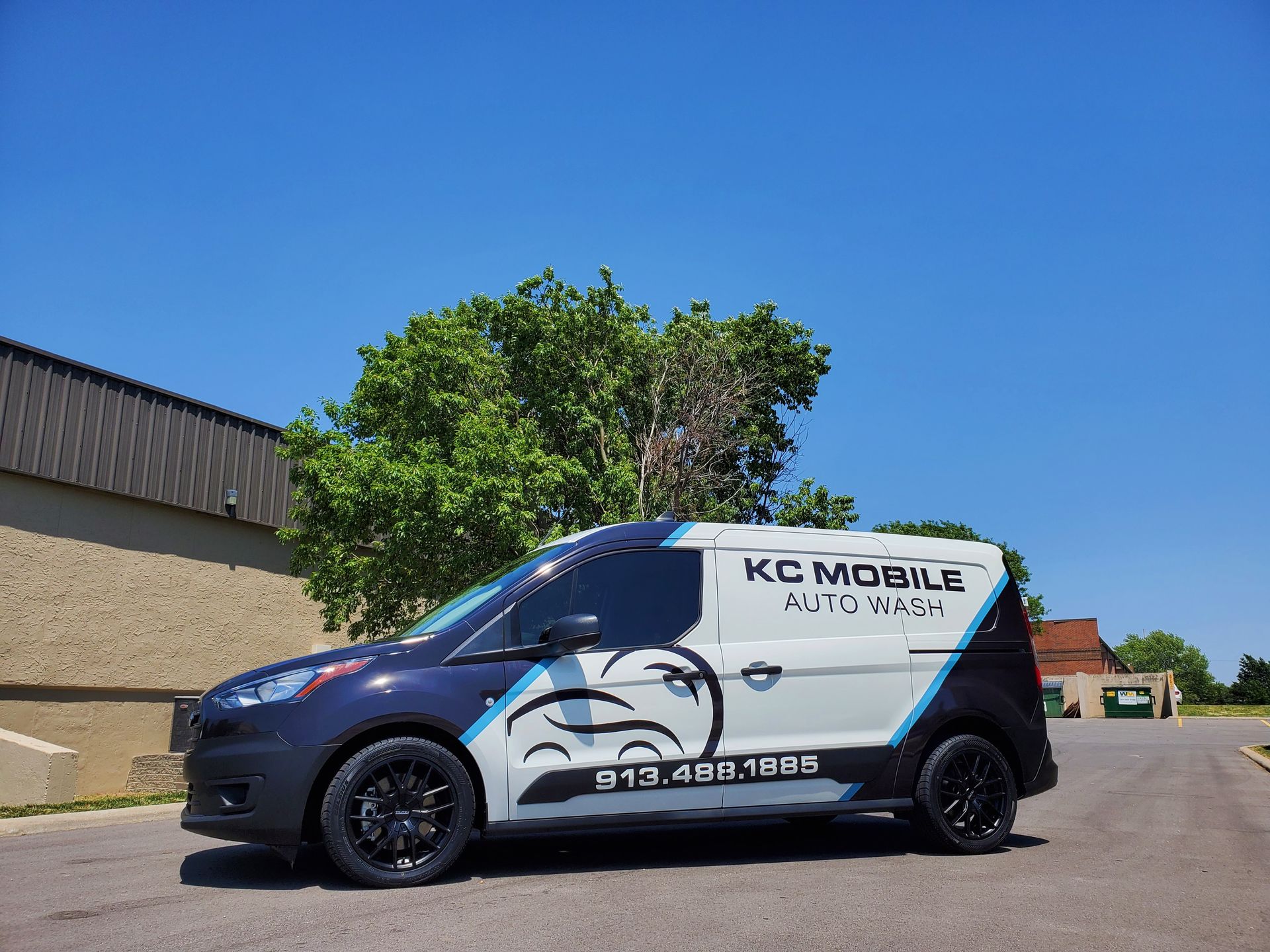 KC Mobile service van parked outdoors beside a building on a sunny day