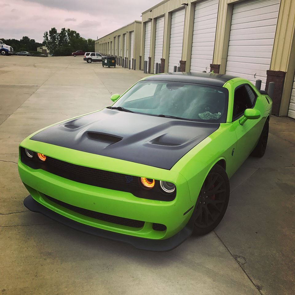 Bright green and black sports car parked outside warehouse garages
