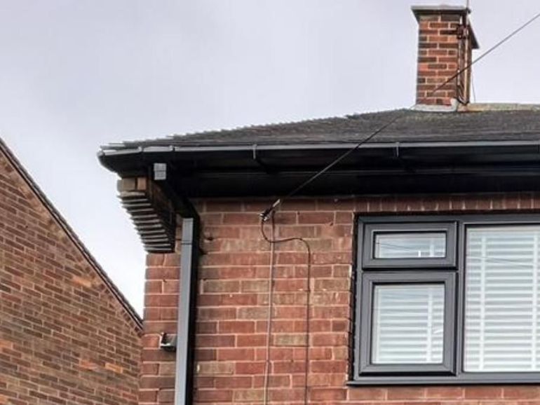 The same house after the fascia, soffit, gutter, downpipe and window were sprayed anthracite