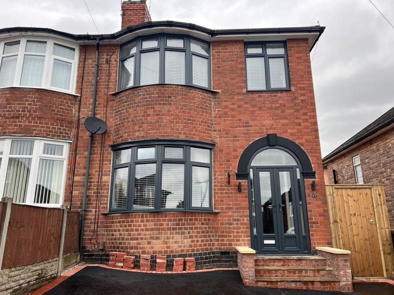 The same bay-fronted semi after its windows and front door were sprayed anthracite grey