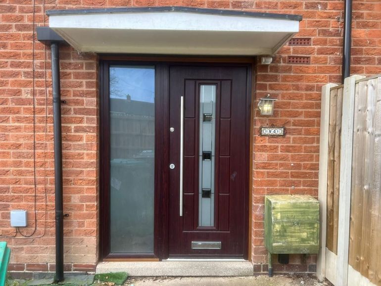 Dark red-brown uPVC front door and glazed side panel under a canopy in Wilford before spraying