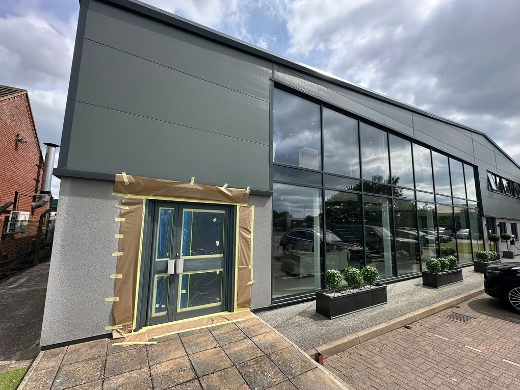 Aluminium double entrance doors on a commercial showroom, glass sheeted and surround masked ready for spraying