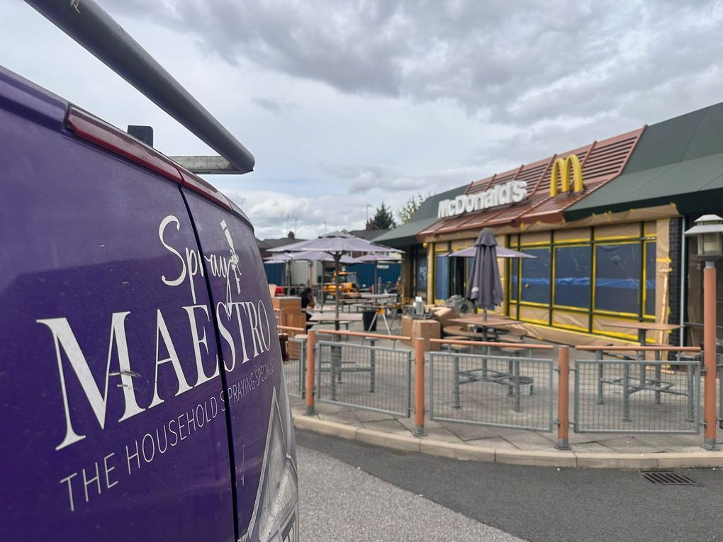 Spray Maestro van beside a quick-service restaurant in Warrington, the shopfront masked and sheeted ready for spraying