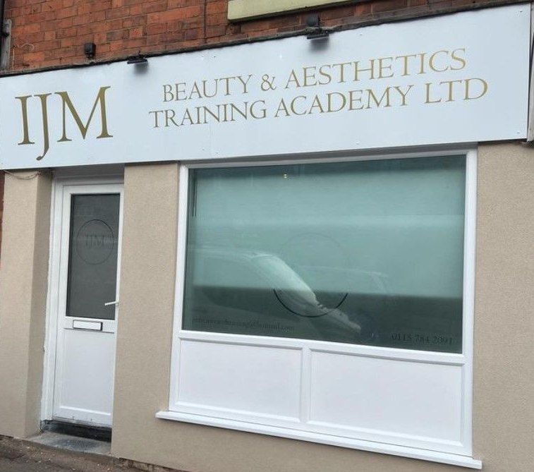 The same shop front after respraying, with stone-coloured walls and a pale sign board for the new occupant