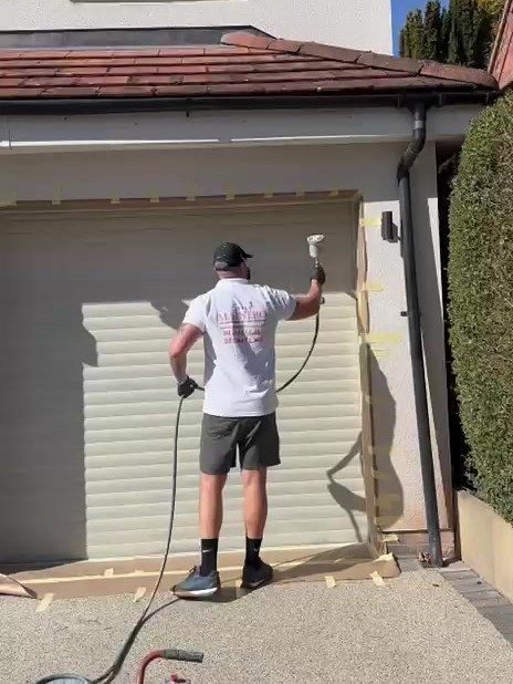 Spray Maestro spraying a roller garage door in a pale cream colour in Loughborough