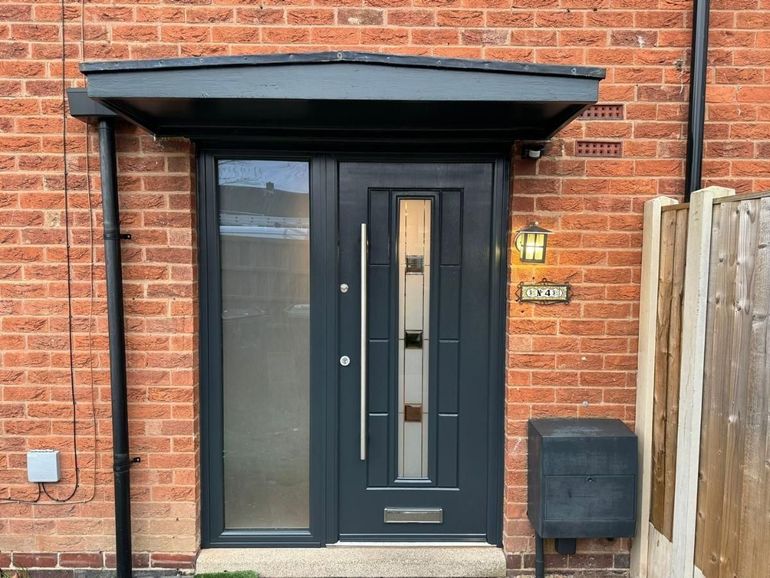uPVC front door and glazed side panel sprayed grey under a canopy
