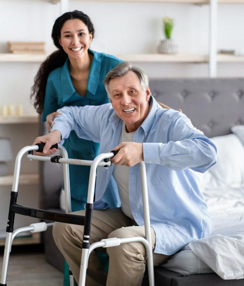 Senior man using a walker with caregiver support, receiving professional in-home elder care services.