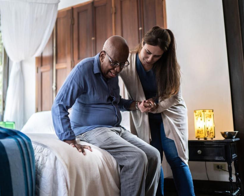 Caregiver helping an elderly man walk safely at home, providing compassionate in-home care services in Chicagoland.
