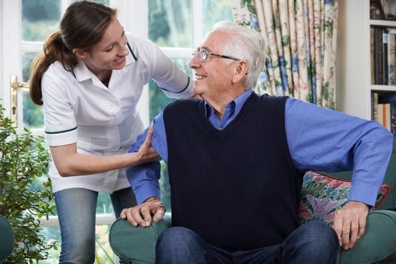 Caring and dedicated in-home caregiver helping an elderly man with daily activities.
