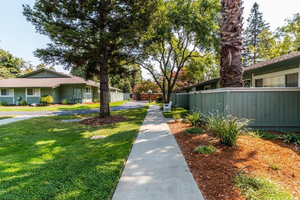 There is a concrete walkway between two houses.