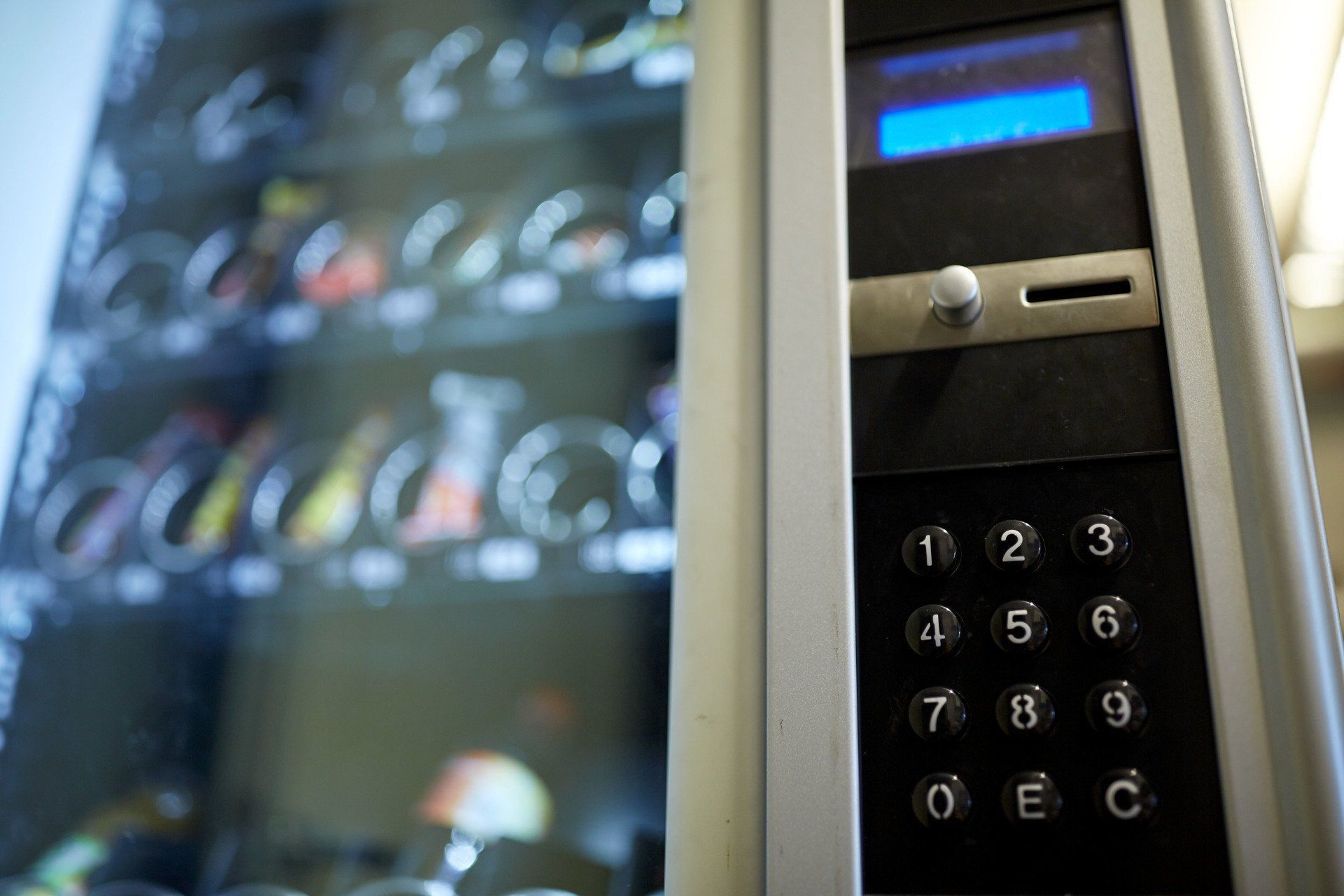 A close up of a vending machine with a keypad.