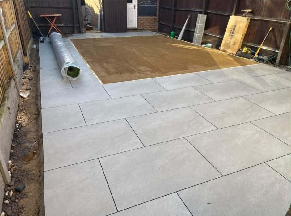 Stone patio bordered by large rocks and mulched garden with greenery.
