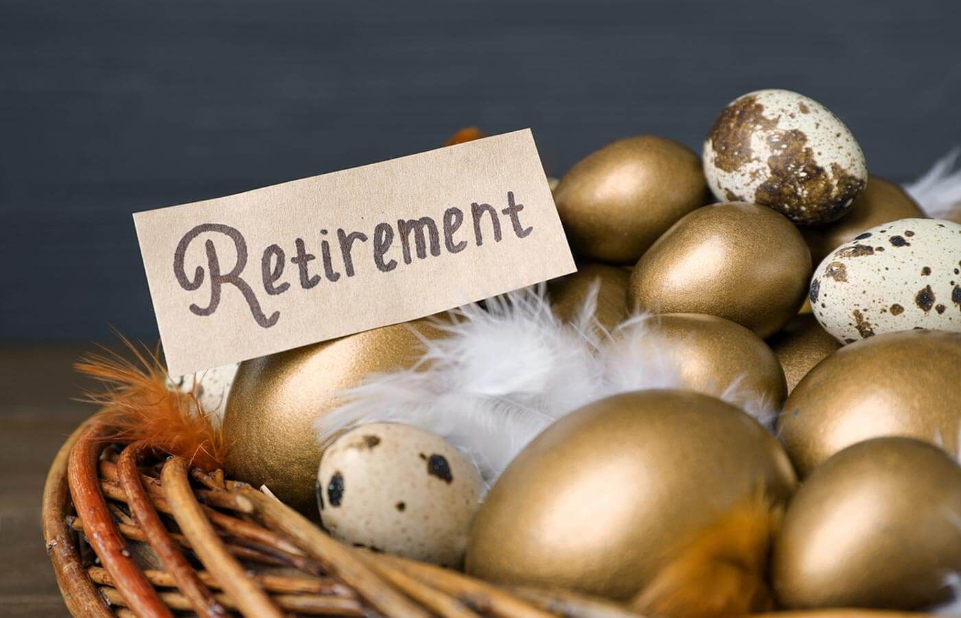 Basket of gold and speckled Easter eggs with a “Retirement” card on a dark background