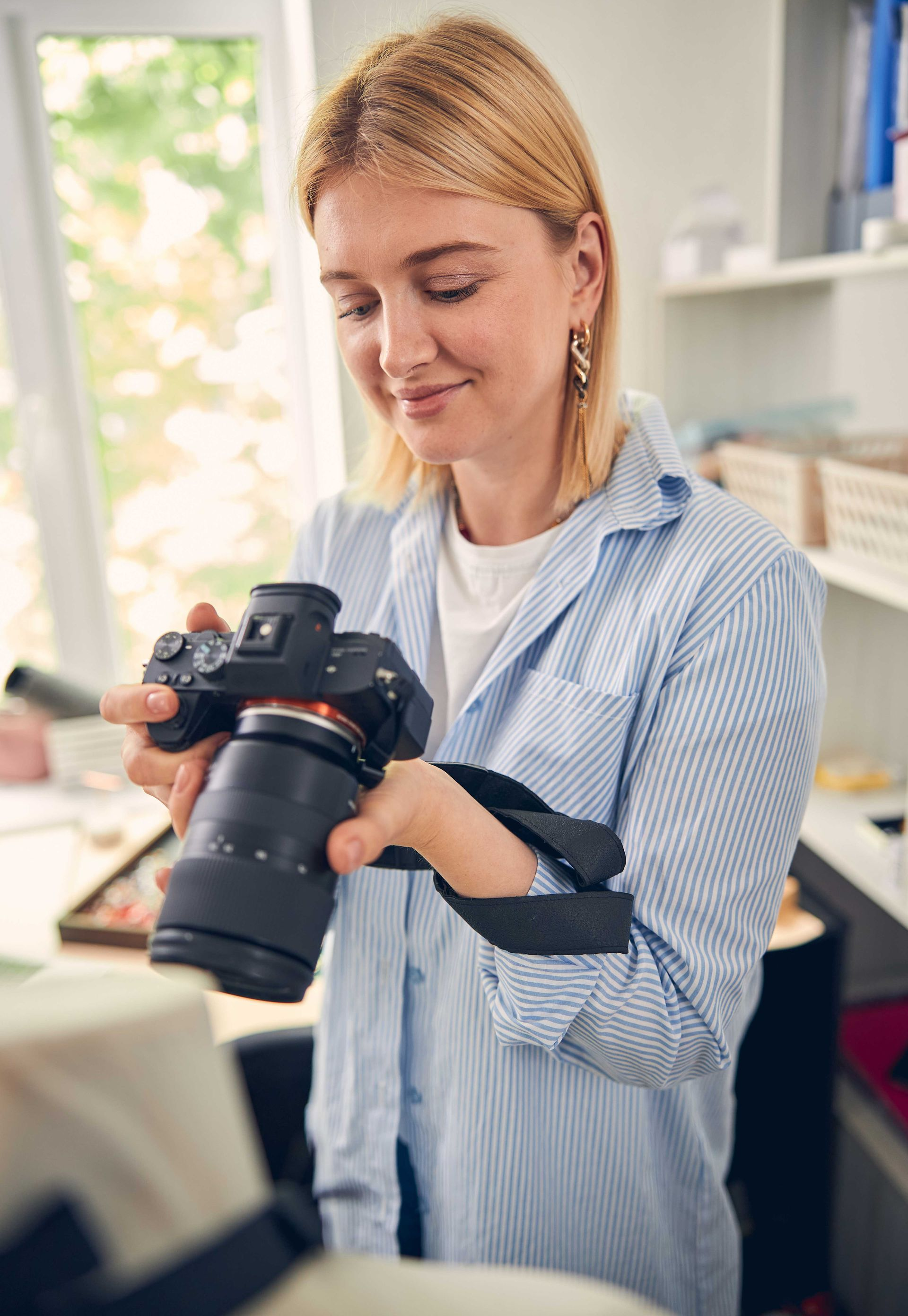 Person holding and examining a camera in a bright room