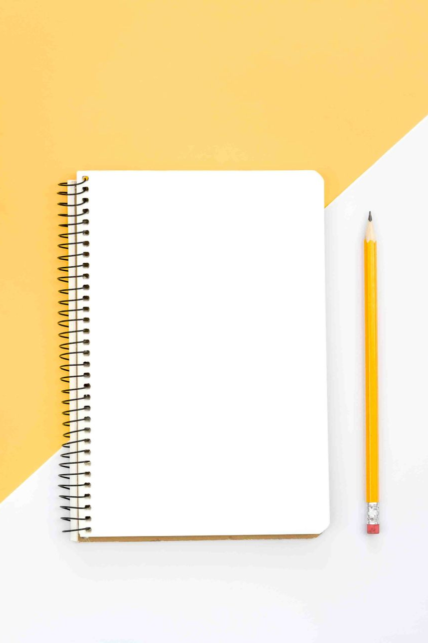 Blank spiral notebook and yellow pencil on a white and yellow background