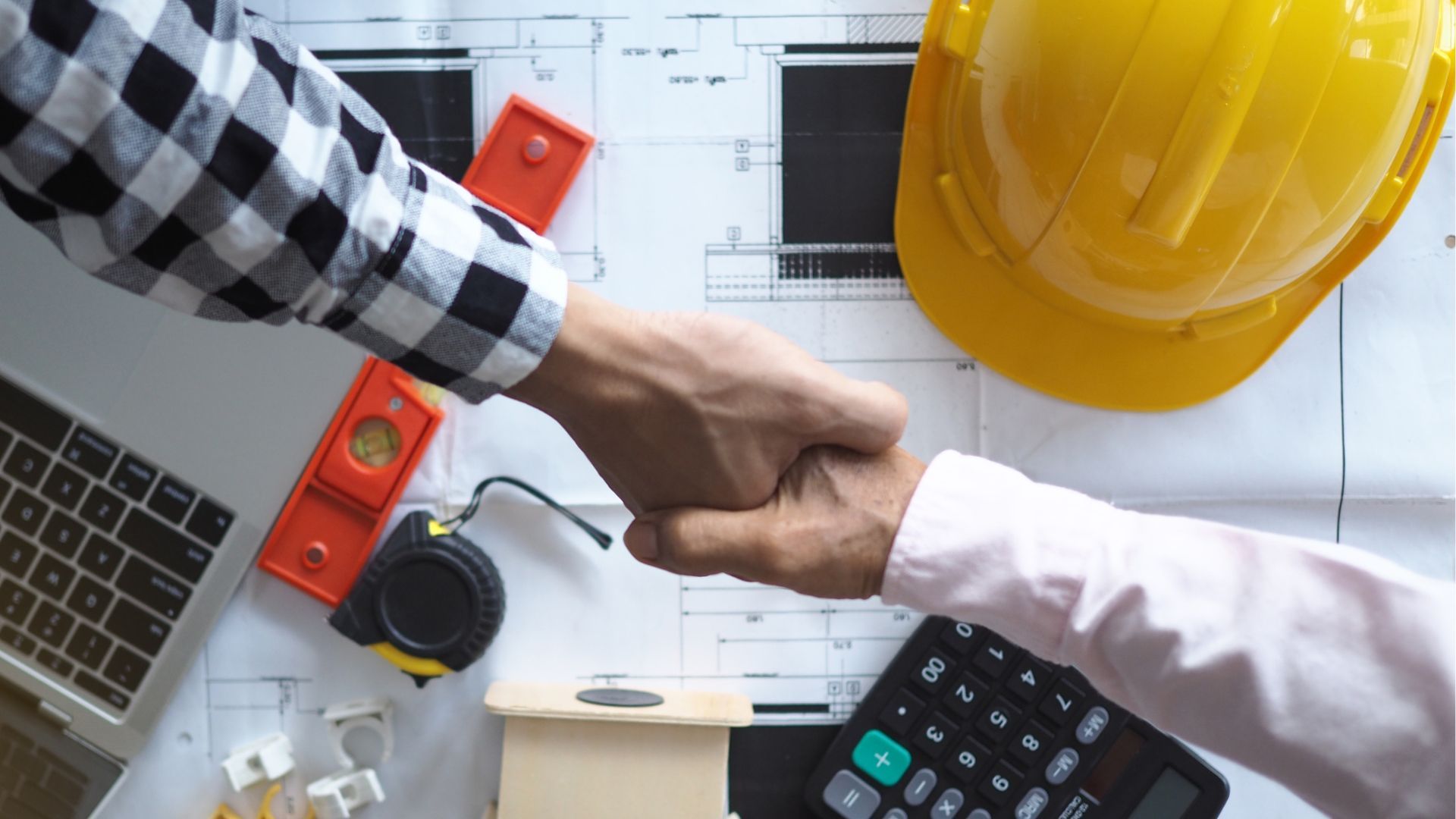 General Contractors Near me shaking hands over a desk
