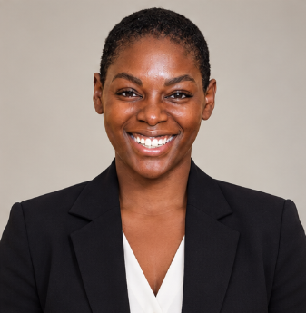 Woman in a blazer and white shirt smiles at the camera against a light blue background.