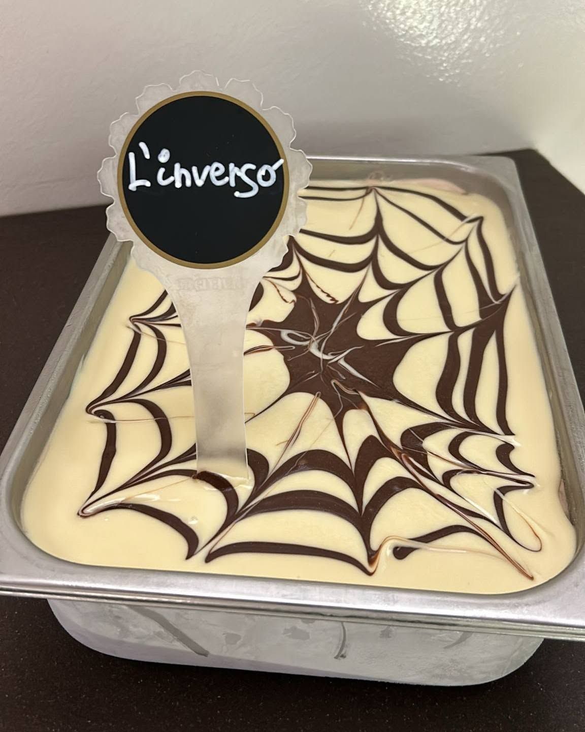 Dessert quadrato con copertura di cioccolato a ragnatela e insegna