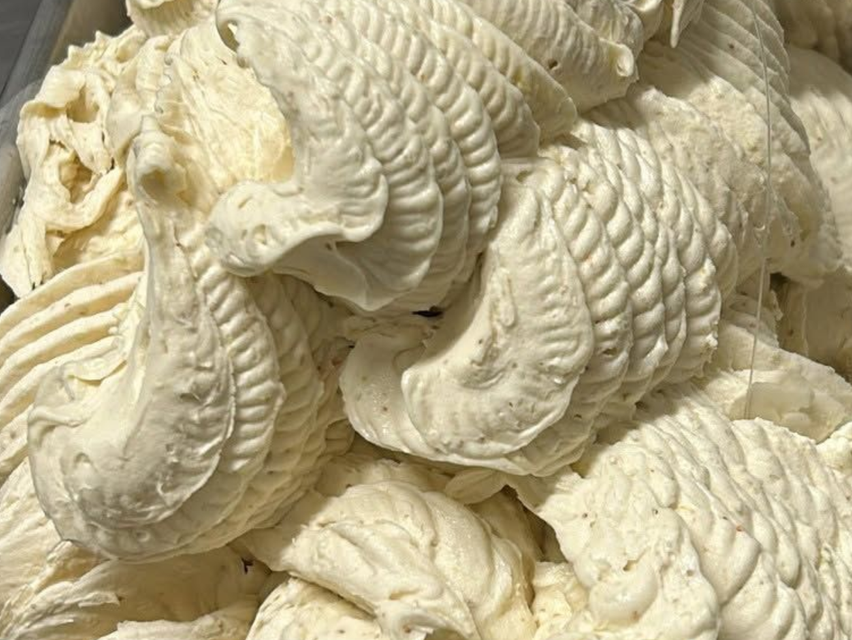 Primo piano di cremose spirali di gelato soft con una superficie ruvida e texturizzata.