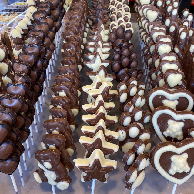 Su un vassoio sono disposte file di biscotti assortiti ricoperti di cioccolato, a forma di stella e di cuore.