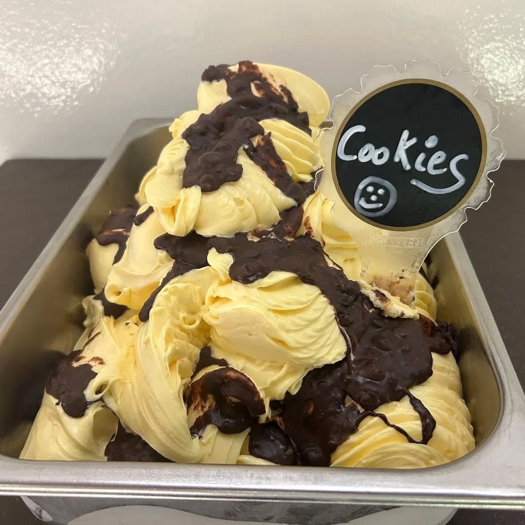 Vassoio di palline di gelato al gusto biscotti e crema, guarnite con una colata di cioccolato e un cartello con la scritta