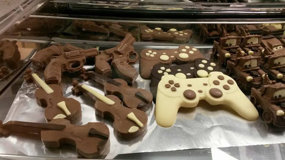 Biscotti assortiti ricoperti di cioccolato a forma di controller di gioco, disposti su un vassoio.