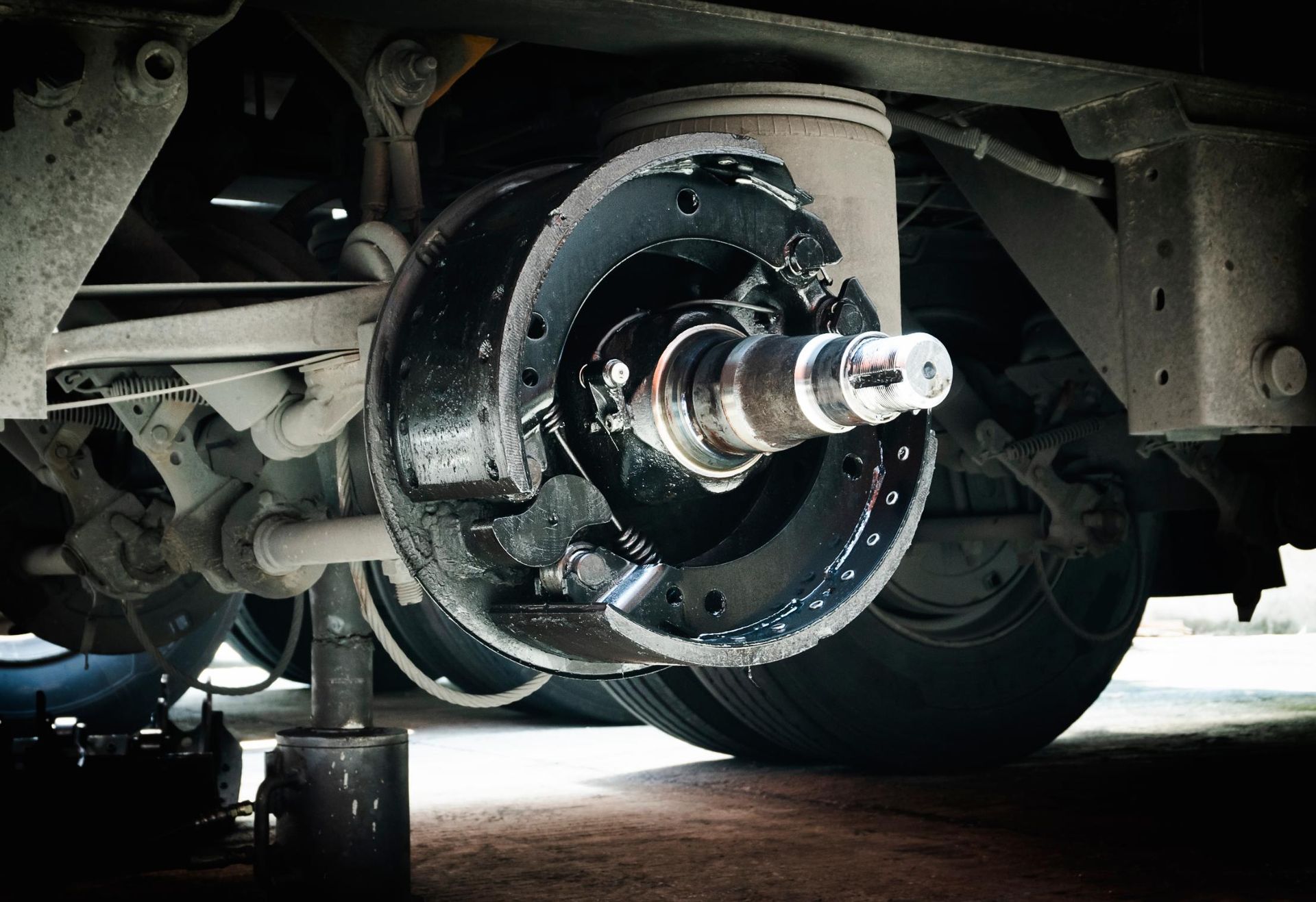 A close-up of a vehicle's drum brake assembly with the wheel removed.