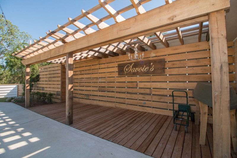 A wooden pergola with a sign that says savoie 's on it.