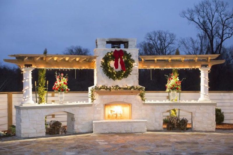 A fireplace decorated for christmas with a wreath on it